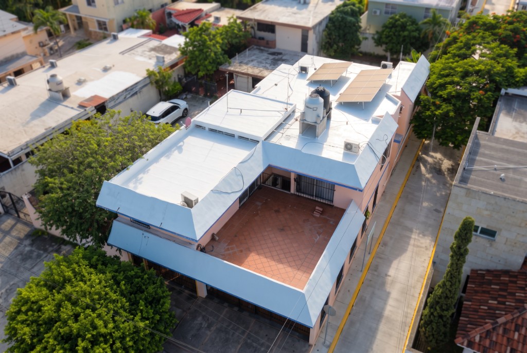 Vista aérea de una casa con toda la azotea impermeabilizada, incluidos pretiles, bajadas, base de tinaco y paneles solares