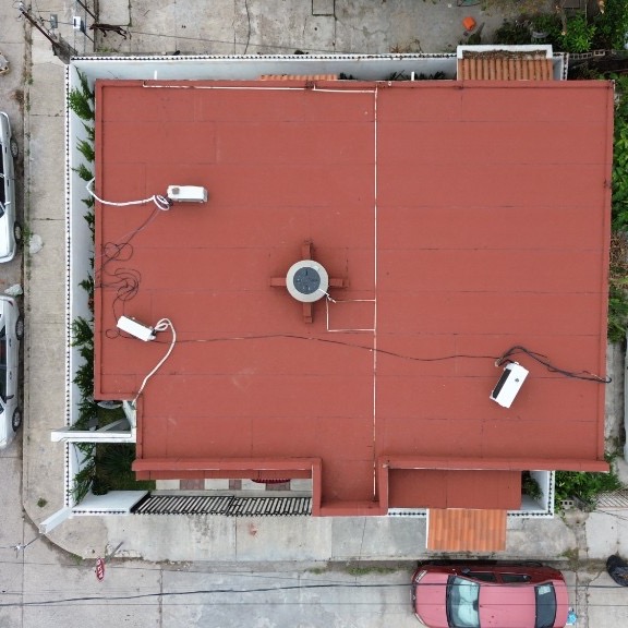 Vista aérea de una azotea residencial impermeabilizada con sistema asfáltico color terracota